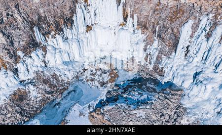 La neve si scioglie e si rifrega creando queste maestose formazioni sulle pareti rocciose. Foto Stock