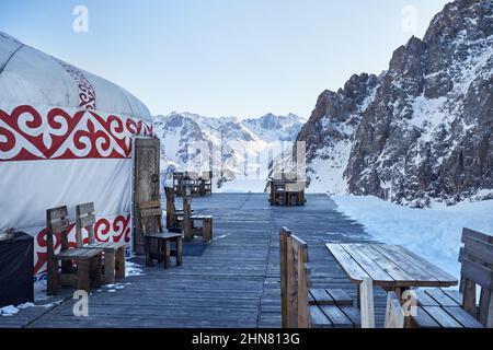 Hotel e Ristorante da Yurt nomade casa complesso con tavolo e sedia presso la stazione sciistica di Shymbulak in Almaty, Kazakhstan. Inverno nevicate all'aperto touri Foto Stock