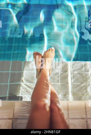 Gambe di lusso. Scatto corto di un piede di donna nell'acqua di una piscina termale. Foto Stock