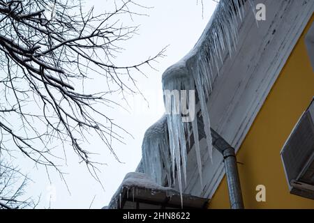 Pericolosi ghiaccioli affilati sulla sommità del tetto Foto Stock