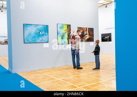 19 ottobre 2021, Mosca, Russia: Padre e figlio guardando le foto della fauna selvatica alla mostra fotografica Golden Turtle Foto Stock