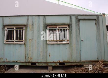 Ufficio container di spedizione verde e resistente alle intemperie vicino al cantiere Foto Stock