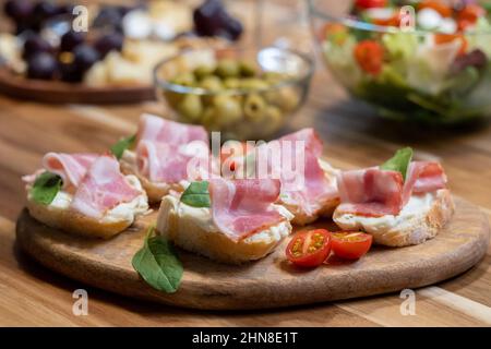 Primo piano di panini con pancetta e pomodori su tavola di legno sul tavolo da pranzo Foto Stock