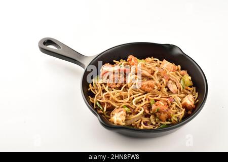 pollo chow mein in padella su sfondo bianco, cucina cinese Foto Stock