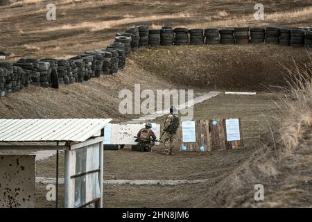 REGIONE DI ZAPORIZHZHIA, UCRAINA - 14 FEBBRAIO 2022 - due soldati esaminano un obiettivo ad un poligono di tiro al centro di addestramento militare istituito entro il 24 Foto Stock