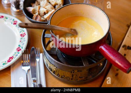 Variante francese della fonduta, Fondue Savoyarde, preparazione al tavolo Foto Stock