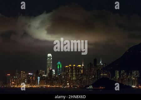 Nuvola illuminata dalle luci della città sopra l'alto livello dell'Isola di Hong Kong vista di notte da Discovery Bay sull'Isola di Lantau Foto Stock