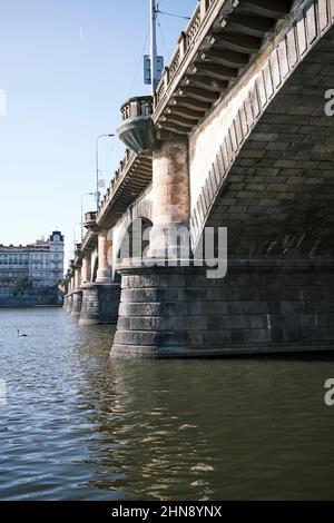 Sotto uno dei vecchi ponti in pietra sul fiume Moldava a Praga Foto Stock