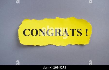 congratulazioni segno di congratulazioni scritto su carta gialla strappata, business concept, vista dall'alto piatto lay. Foto Stock