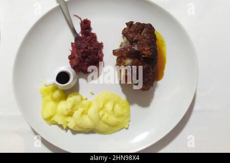 Maialino arrosto cotto al forno e patate bollite Foto Stock