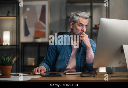 Architetto uomo maturo che lavora al computer alla scrivania in ufficio. Foto Stock