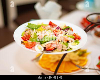 Gustosa insalata di pesce con verdure miste sul tavolo Foto Stock