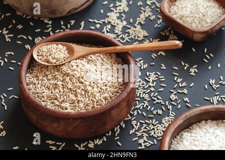 Set di diversi tipi di riso e cereali in ciotole di legno e. Foto Stock