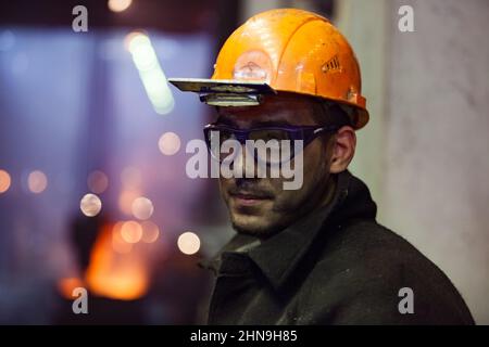 Temirtau, Kazakistan - 08 giugno 2012: Fonderia Arcelor Mittal. Produzione di acciaio. Primo piano di foto di giovane metallurgista con il volto sporco in protezione Foto Stock