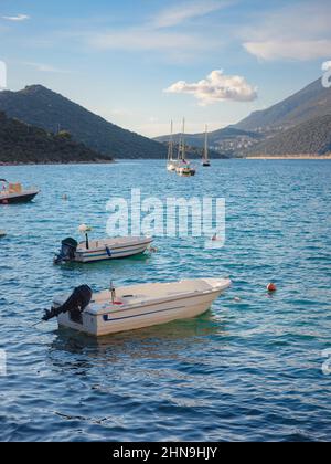 Piccole barche da pesca al tramonto - Kas Turchia. Barche e montagne sulla costa turca del Mediterraneo, popolare destinazione turistica Foto Stock