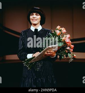 Der Große Preis, ZDF Quizshow, musikalischer Gast: Mireille Mathieu, auf dem Bild mit Blumenstrauß, 1981. Der Grosse Preis, ZDF Quiz show, ospite: Cantante francese Mireille Mathieu, sulla foto con bouquet, 1981. Foto Stock