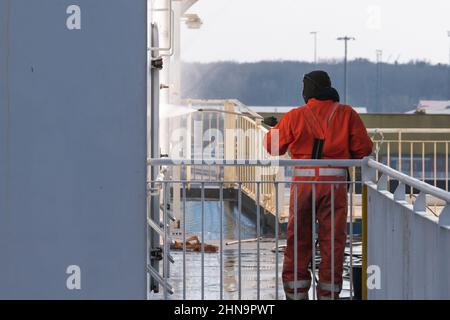 Un operatore che spruzza una parete con un pulitore ad alta pressione Foto Stock