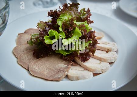 piatto di carne in un ristorante decorato con verdure di prezzemolo riccio Foto Stock