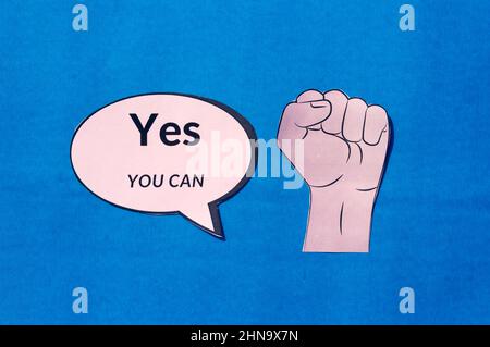 Mano umana solida con testo di motivazione Sì si può su bolla di discorso isolato su sfondo blu. L'immagine concettuale mostra che si dispone della capacità str Foto Stock