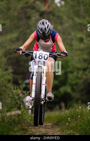 ragazza ciclista a cavallo sul sentiero forestale in mountain bike Foto Stock