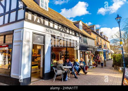 Persone che si siedono fuori da una panetteria in una giornata invernale soleggiata, Churchyard Walk, Hitchin, Hertfordshire, Regno Unito Foto Stock