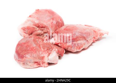 Tre guance di maiale pezzi crudi su sfondo bianco Foto Stock