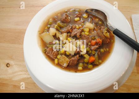 Primo piano di abbondante stufato di manzo servito in un recipiente bianco Foto Stock