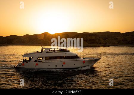 I turisti fanno un giro su uno yacht a due piani sul mare rosso sullo sfondo di un tramonto luminoso. Sharm el Sheikh Egitto. Ottobre 15, 2021 Foto Stock