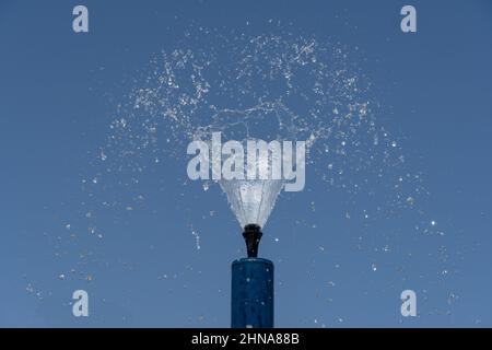 Una fontana blu spruzza acqua parco spruzzatori spruzzare acqua sopra per il divertimento estivo dei bambini. Foto Stock