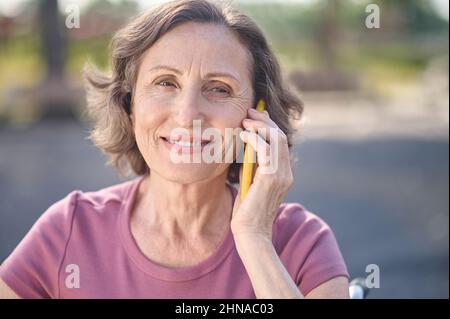 Donna sorridente parlando al telefono Foto Stock