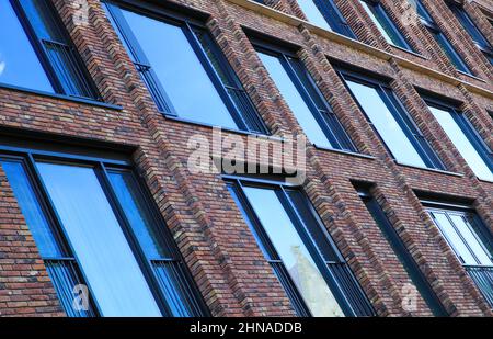 Vista obliqua sulla moderna facciata in mattoni rossi con finestre in vetro blu - Maastricht, Paesi Bassi Foto Stock