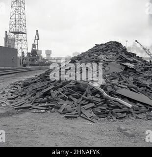 1950s, storica, una grande pila di rifiuti scartati dalla produzione di metallo presso l'Abbey Works a Port Talbot, il sito industriale della Steel Company of Wales. Foto Stock