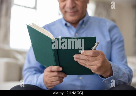 Primo piano della scrittura dell'uomo in diario o giornale nel paese Foto Stock