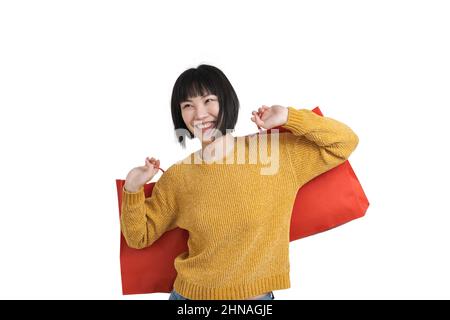 Giovane donna asiatica sorridente e in possesso di borse per lo shopping, isolato. Foto Stock