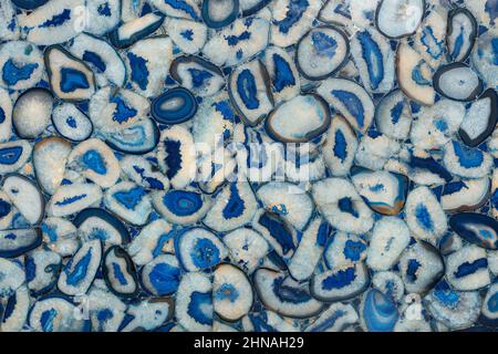 Lussuoso pannello di pietra sfondo di pietre color agata blu con fiori bianchi. Primo piano. Foto Stock