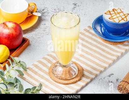 Tè Kumquat Lemon ghiacciato in un bicchiere su tappeto con bevanda a base di grigio per la colazione Foto Stock