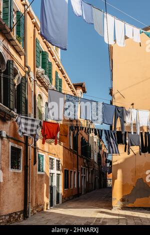 Lavanderia appeso fuori dalla tipica facciata veneziana, Italy.Narrow strada con edifici colorati e vestiti asciutti su corda, Venice.clean vestiti asciugando all'aperto Foto Stock