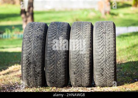 Set di pneumatici invernali usati rimossi dalla vettura dopo la stagione fredda, la primavera Foto Stock