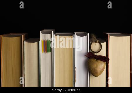 Libri di lato con cuore di legno Foto Stock