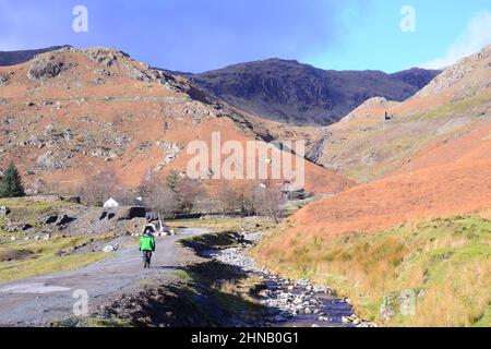 Un uomo cammina lungo un sentiero della montagna nella valle di Coniston Copper Mines, Lake District o Lakes, Cumbria, UK. Foto Stock