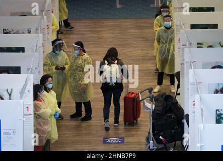 Richmond, Canada. 15th Feb 2022. Gli operatori medici sono visti presso il sito di test COVID-19 all'interno della sala degli arrivi dell'aeroporto internazionale di Vancouver a Richmond, British Columbia, Canada, il 15 febbraio 2022. Il Canada sta allentando i requisiti dei test all'arrivo per i viaggiatori completamente vaccinati a partire dal 28 febbraio, poiché l'ultima ondata di COVID-19 guidata dalla variante Omicron ha superato il suo picco, l'Agenzia per la Sanità pubblica del Canada ha annunciato Martedì. Credit: Liang Sen/Xinhua/Alamy Live News Foto Stock