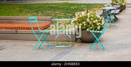 Set di mobili da giardino pieghevoli in legno tavolo e sedie all'aperto. Sedia pieghevole e tavolo in un patio durante la giornata estiva Foto Stock