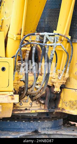 Primo piano dei tubi flessibili idraulici su un grande escavatore giallo Foto Stock