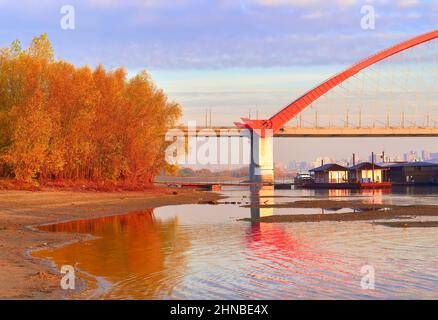 La riva del fiume OB. Il supporto del ponte ad arco di Bugrinsky sulla spiaggia sabbiosa in autunno dorato. Novosibirsk, Siberia, Russia, 2021 Foto Stock