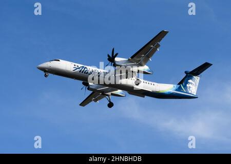 SeaTac, WA, USA - 11 febbraio 2022; servizio regionale Alaska Airlines Horizon che atterra a SeaTac con un velivolo Bombardier DHC 8-400 Foto Stock