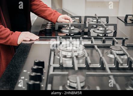 Donna in un negozio sceglie per comprare una stufa a gas. Primo piano con le mani Foto Stock
