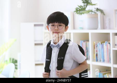 Un ragazzo che porta una borsa della scuola per il nuovo semestre Foto Stock