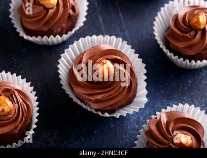 Meringa, cupcake al cioccolato Pavlova con panna e noci. Foto Stock