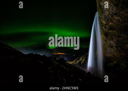 Aurora borealis sopra la cascata Seljalandsfoss in Islanda Foto Stock