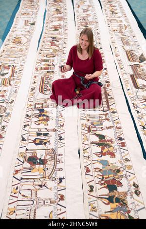 Mia Hansson con la sua replica full-size del Bayeux Tapestry a Wisbech, Cambridgeshire, che finora ha preso quasi sei anni per cucire, con mia che passa fino a 10 ore al giorno lavorando su di esso a casa sua a Wisbech. L'insegnante della scuola elementare di 47 anni ha superato la metà di gennaio di quest'anno, avendo realizzato 34,2 metri (112 piedi) di opere d'arte di 68,38 metri (224 piedi), che saranno esposte presso la St Peter's Church Hall di Wisbech il 12 aprile. Data immagine: Martedì 15 febbraio 2022. Foto Stock
